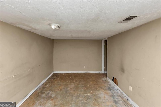 interior space with a textured ceiling, visible vents, and baseboards