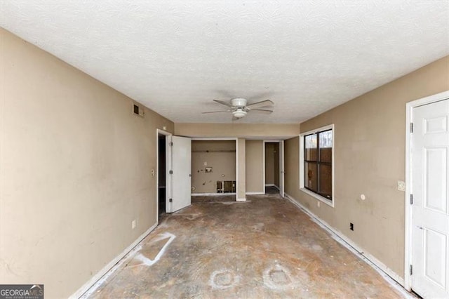 interior space with a textured ceiling, visible vents, and a ceiling fan