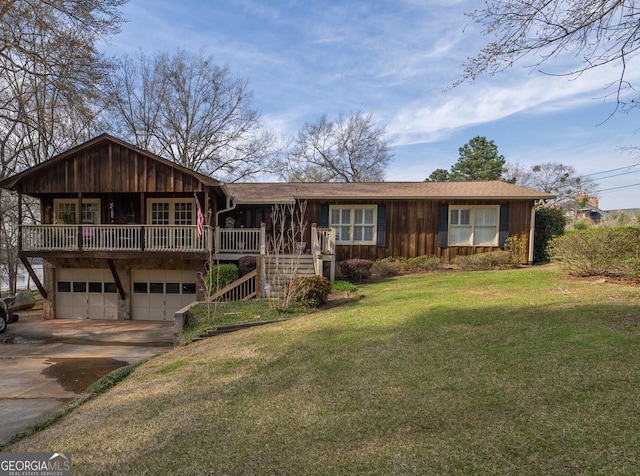 view of front of house with concrete driveway, an attached garage, board and batten siding, a front yard, and stairs