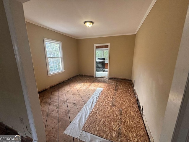 unfurnished room with ornamental molding and wood finished floors