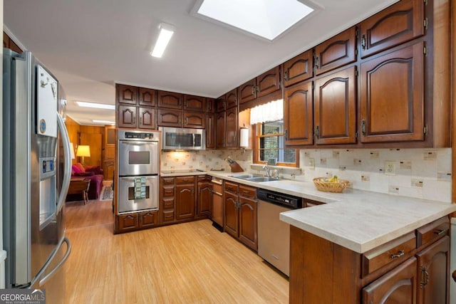 kitchen with appliances with stainless steel finishes, light countertops, and a sink