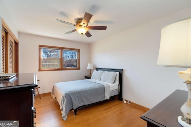 bedroom featuring light wood-type flooring, baseboards, and a ceiling fan