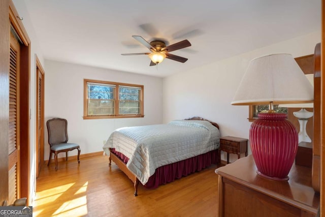 bedroom featuring a ceiling fan, light wood-style flooring, and baseboards