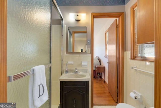 full bathroom with tile walls and vanity