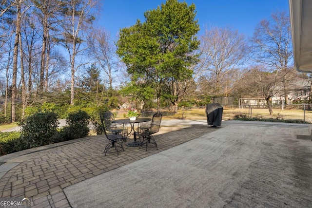 view of patio with a grill and fence