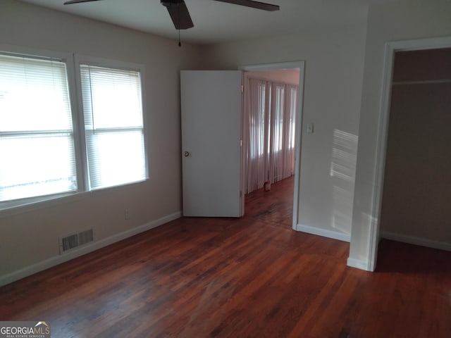 unfurnished bedroom with a ceiling fan, baseboards, visible vents, and wood finished floors