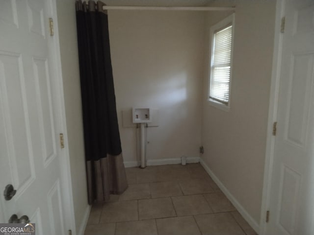 interior space featuring baseboards and light tile patterned flooring