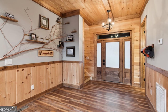 entrance foyer with wood ceiling, visible vents, and wooden walls