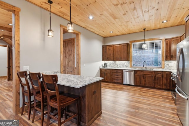 kitchen with appliances with stainless steel finishes, backsplash, a sink, and wood ceiling