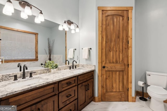 full bath with marble finish floor, double vanity, a sink, and toilet