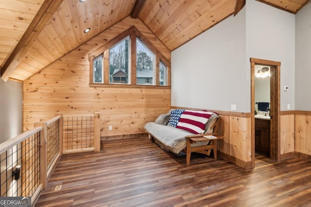 unfurnished room featuring lofted ceiling with beams, wainscoting, wood walls, wood finished floors, and wooden ceiling