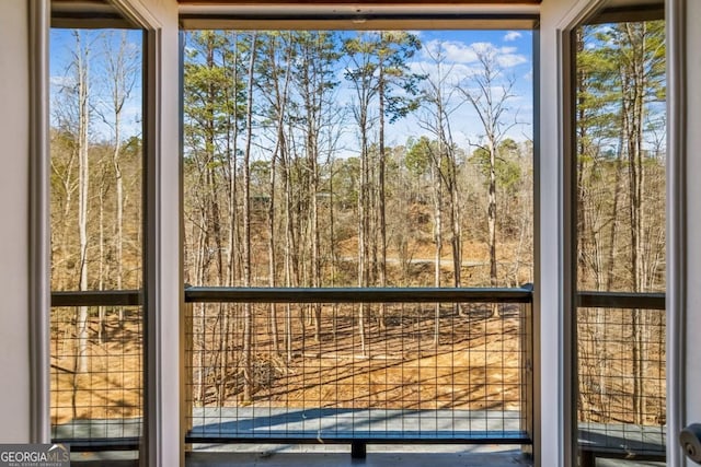 unfurnished sunroom with a wooded view