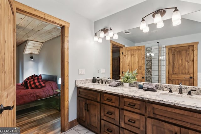 bathroom with visible vents, a sink, ensuite bath, and double vanity