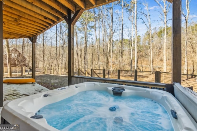 exterior space featuring a hot tub and a forest view