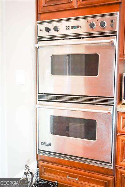 kitchen with stainless steel double oven and brown cabinets