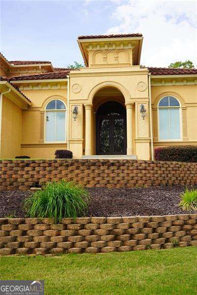 view of exterior entry featuring a tiled roof and stucco siding