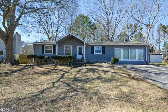 ranch-style home with driveway, crawl space, a front yard, and fence