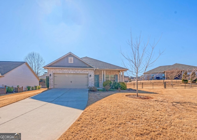 view of front of house featuring brick siding, an attached garage, fence, driveway, and a front lawn