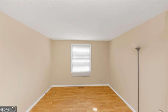 unfurnished room with light wood finished floors and baseboards