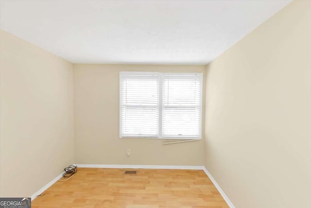 empty room with baseboards, visible vents, and light wood-style floors