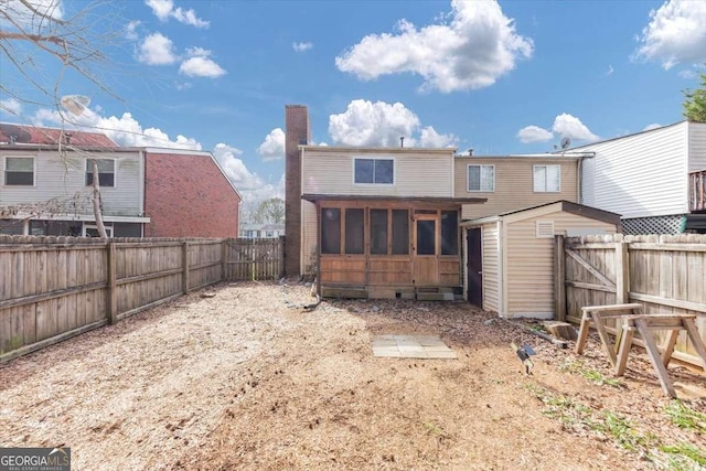 back of property with a sunroom and a fenced backyard