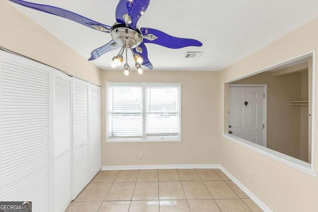 unfurnished room featuring baseboards, visible vents, a ceiling fan, and light tile patterned flooring