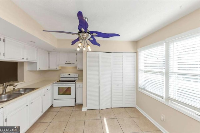 kitchen featuring white electric range oven, under cabinet range hood, white cabinets, and a sink