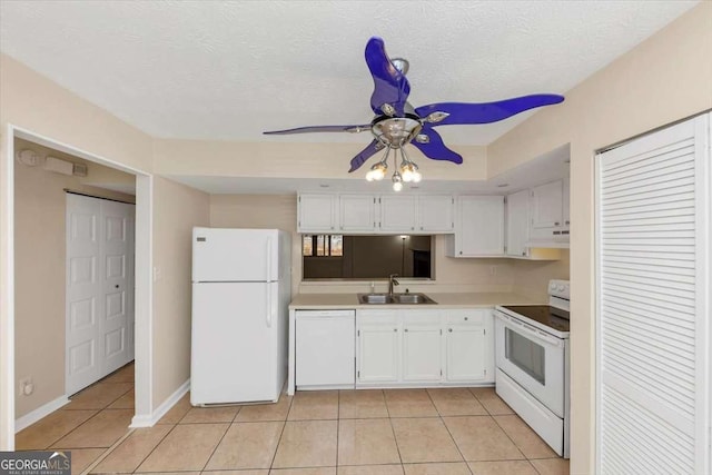 kitchen featuring light tile patterned floors, light countertops, white cabinetry, a sink, and white appliances