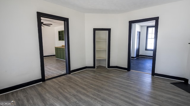 unfurnished room with dark wood-type flooring and baseboards