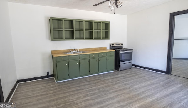 kitchen featuring dark wood-style flooring, stainless steel electric range, a sink, and green cabinetry