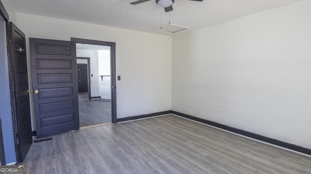 unfurnished room featuring ceiling fan, a textured ceiling, wood finished floors, visible vents, and baseboards