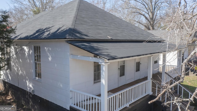 view of home's exterior featuring a shingled roof and concrete block siding