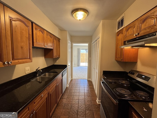 kitchen featuring under cabinet range hood, a sink, visible vents, appliances with stainless steel finishes, and dark stone counters