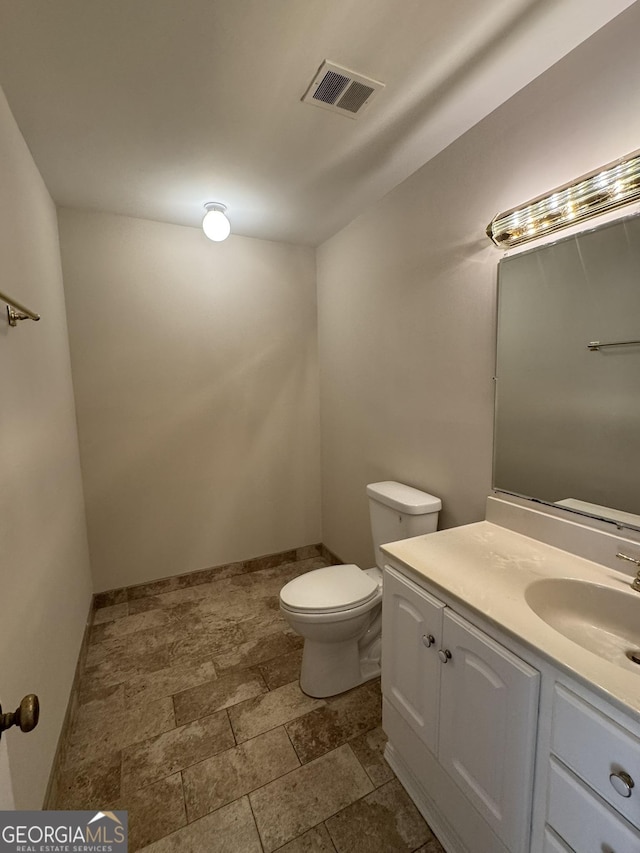 bathroom with toilet, baseboards, visible vents, and vanity