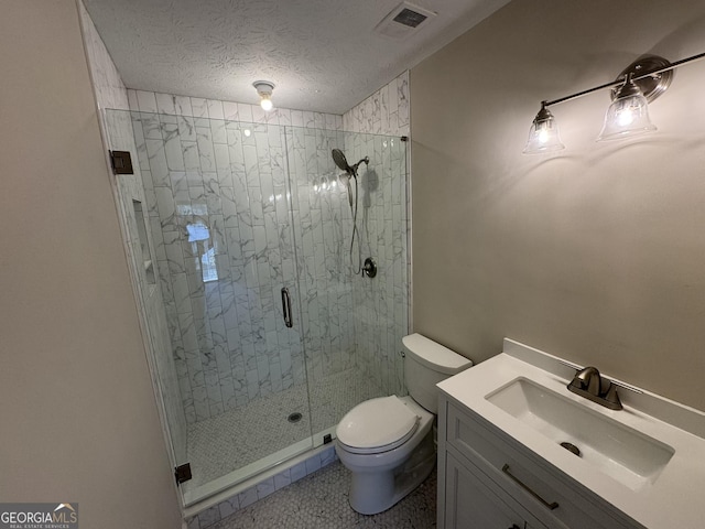 bathroom with a textured ceiling, toilet, vanity, visible vents, and a shower stall