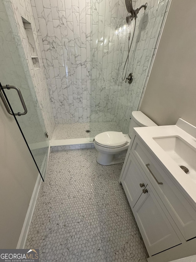 bathroom featuring toilet, a stall shower, and vanity