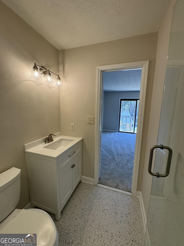 bathroom with baseboards, a textured ceiling, toilet, and vanity