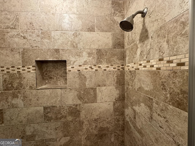 interior details featuring tiled shower