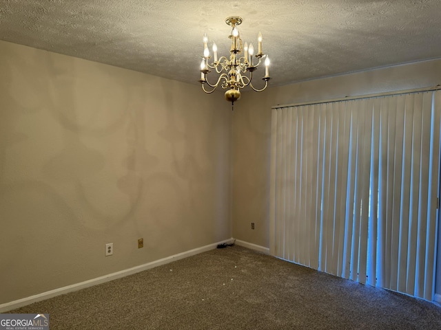 unfurnished room with carpet floors, a notable chandelier, a textured ceiling, and baseboards