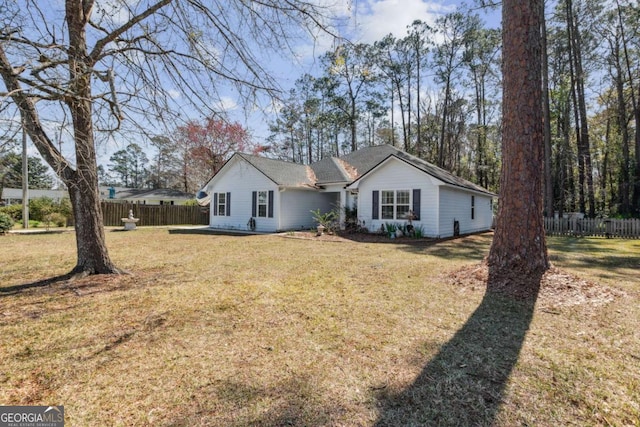 ranch-style house with a front yard and fence