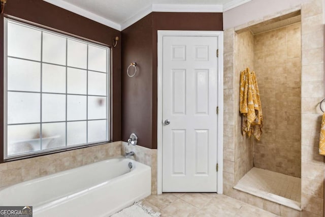 bathroom featuring tile patterned floors, crown molding, a tile shower, and a bath