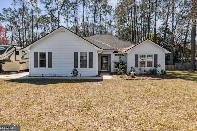 single story home with roof with shingles, fence, and a front lawn