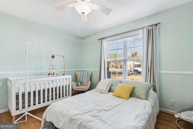 bedroom featuring ceiling fan, baseboards, and wood finished floors