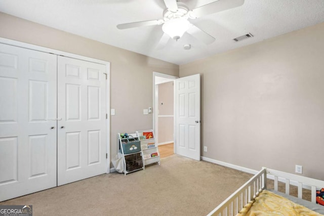 bedroom featuring carpet flooring, a ceiling fan, visible vents, baseboards, and a closet