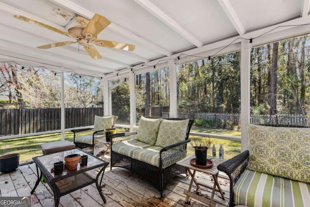 sunroom / solarium featuring ceiling fan and beam ceiling