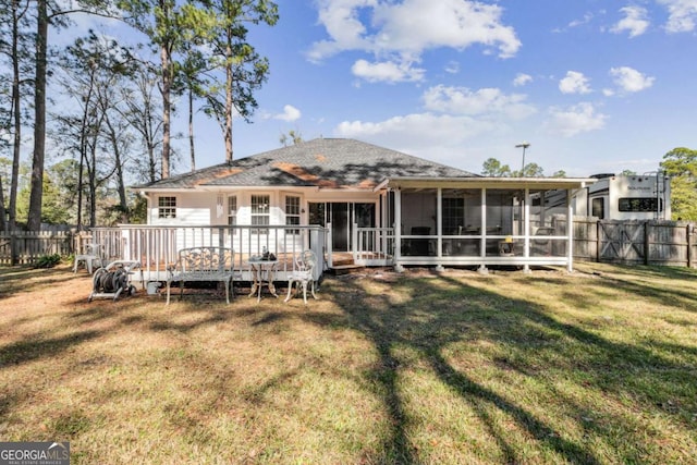 rear view of property with a wooden deck, a yard, fence, and a sunroom