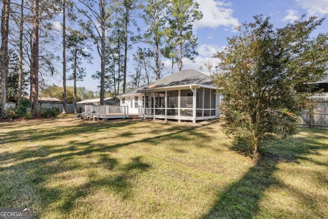 view of yard with a sunroom, a fenced backyard, and a wooden deck