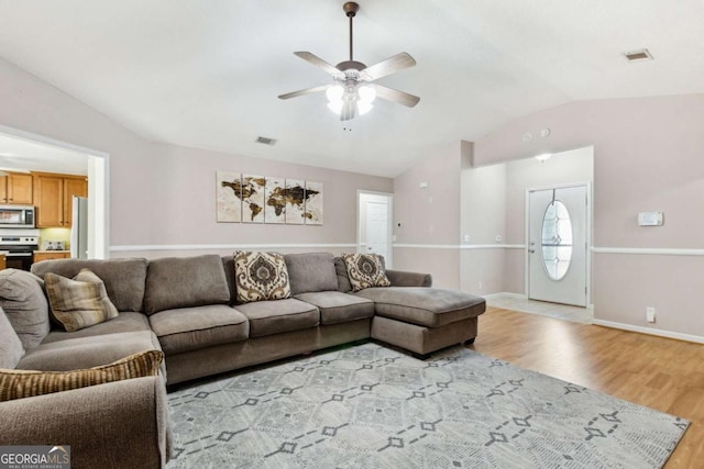 living room featuring visible vents, vaulted ceiling, light wood finished floors, and ceiling fan