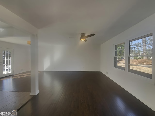 spare room with ceiling fan, dark wood-style flooring, and baseboards