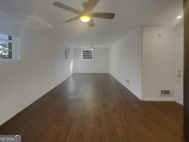 empty room with a ceiling fan, visible vents, and wood finished floors